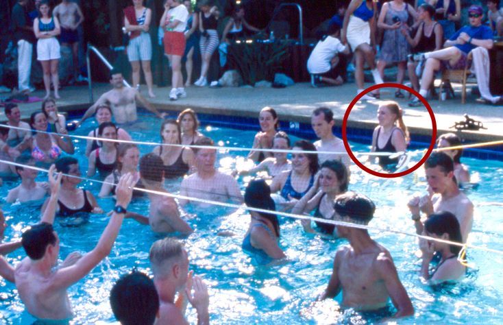 Mariette Lindstein (center back in pool, with ponytail) playing water volleyball with other staff at Golden Era Productions 1995.
